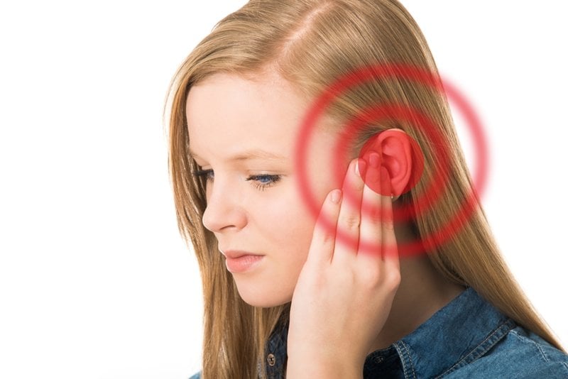 Woman touching ear with signals radiating Woman touching ear with signals radiating